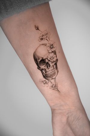 Experience Viola's mastery in black and gray micro realism with this stunning tattoo featuring a delicate flower intertwined with a skull.