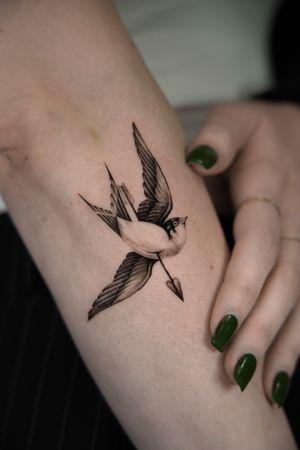 Exquisite black and gray tattoo of a swallow and arrow, perfectly executed by Viola in micro realism style.