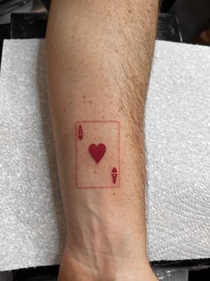 Get a stunning ace of hearts card tattoo by renowned artist Viola, featuring intricate illustrative details.