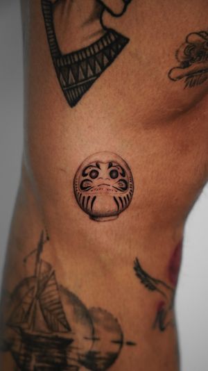 Get inspired by Viola's intricate illustrative style with this delicate daruma tattoo design.