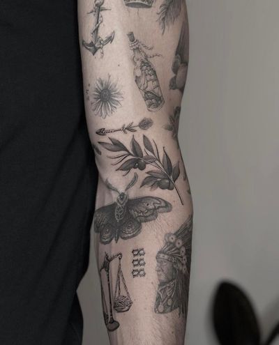 Stunning black and gray piece by Ry Roger featuring a realistic moth, patchwork design, arrow, and branch. A perfect blend of artistry and symbolism.