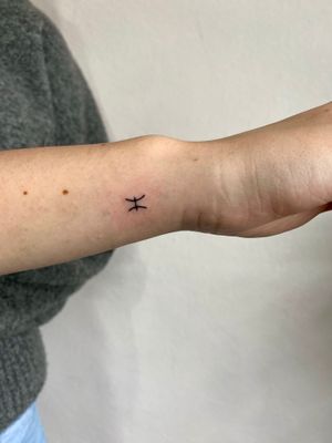 Embrace your inner Pisces with this delicate hand-poked tattoo by Charlotte Pokes. Perfect for astrology lovers!