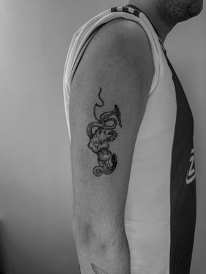 Unique tattoo by Oliver Soames featuring a captivating fusion of snake and man in woodcut style.