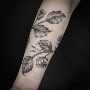 Discover the delicate beauty of nature with this illustrative tattoo by artist Jenny Dubet featuring a stunning flower, branch, and leaves motif.