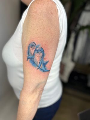Discover the beauty of this illustrative watercolor tattoo featuring a playful dolphin in vibrant colors by jadeshaw_tattoos.