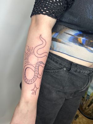 Experience the cosmic allure with this exquisite fine line tattoo featuring a sun, star, and snake motif by jadeshaw_tattoos.