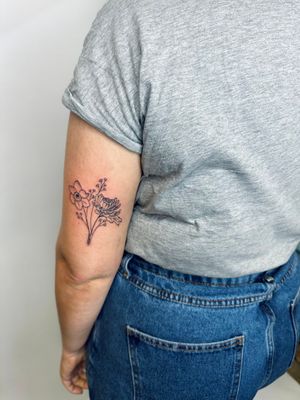 Elegant and intricate flower bouquet tattoo in fine line style by the talented artist Jade Shaw. Perfect for a delicate and unique touch. 