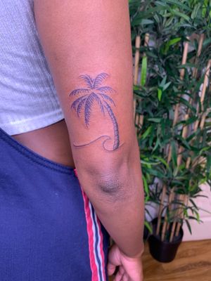 Capture the essence of the beach with this illustrative tattoo of a wave and palm tree by jadeshaw_tattoos.