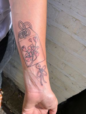 Get a charming tattoo by jadeshaw_tattoos for good luck and blessings with omamori and cherry blossom motifs.