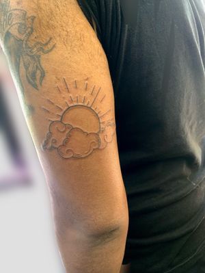 Experience the beauty of nature with this illustrative tattoo by jadeshaw_tattoos. Sun peeks through fluffy clouds in a stunning design.