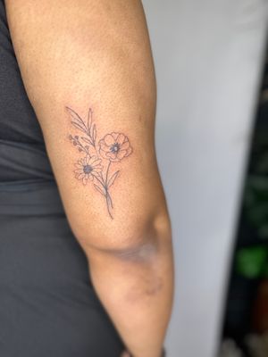 Intricate fine line design by jadeshaw_tattoos capturing a stunning bundle of blooming flowers.