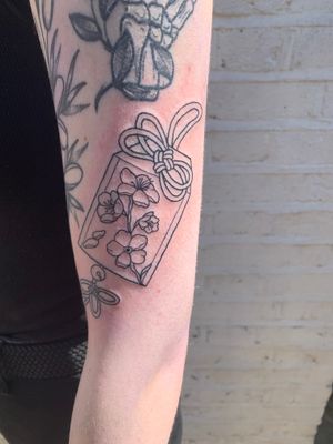 Beautifully detailed tattoo by jadeshaw_tattoos featuring a stunning combination of a flower, charm, and bag design.