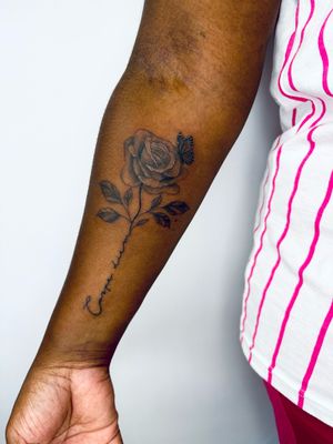 Beautiful black & gray tattoo featuring a butterfly and rose, done by jadeshaw_tattoos on dark skin.