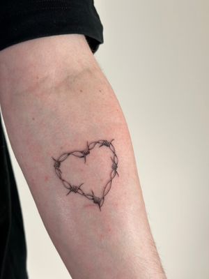 Get a unique illustrative tattoo featuring a heart wrapped in barbed wire by Saka Tattoo, showcasing their artistic talent and attention to detail.