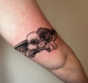 Get a striking black and gray illustrative tattoo of the adorable Gizmo from Gremlins by the talented artist Miss Vampira.