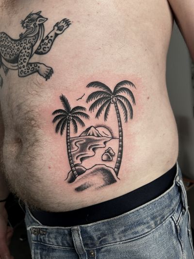 Get lost in the serene beauty of a traditional style beach and palm tree tattoo, expertly crafted by Barney Coles.