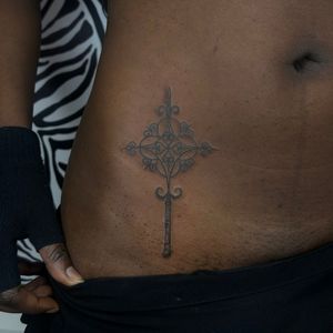 Let Zanzi La Vey create a captivating illustrative tattoo featuring a dark skin tone and mystical wand design.