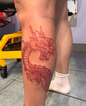 A wraparound red dragon tattoo that goes all the way down to a foot