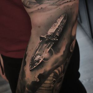 Exquisite black and gray knife tattoo by renowned artist Craig Hicks, capturing the sharpness in stunning detail.