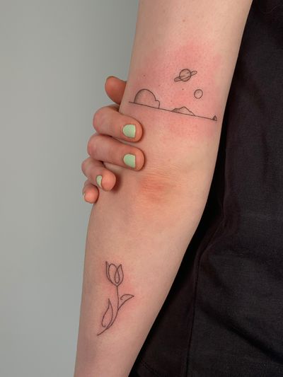 Capture the beauty of space with this stunning fine line tattoo featuring a planet landscape by Chloe Hartland.