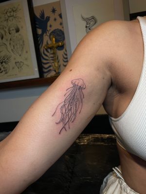Experience the intricate beauty of a fine line, illustrative jellyfish tattoo expertly designed by Julia Bertholdi. Dive into the world of underwater elegance.