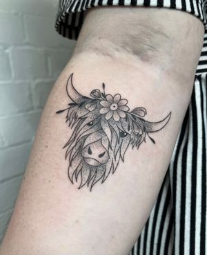 Unique hand-poked tattoo by Marketa.handpoke featuring a cow and flower design, created in dotwork style with illustrative elements.