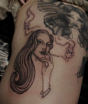 Get mesmerized by Julia Bertholdi's stunning illustrative tattoo of a woman gracefully holding a cigarette, exuding an air of mystery and allure.