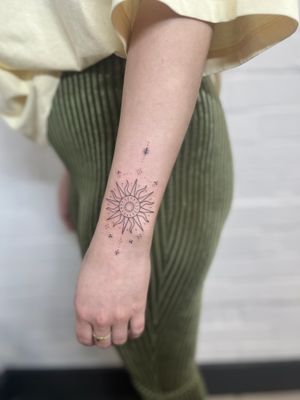 Experience the intricate beauty of a fine line hand-poked ornamental sun tattoo by the talented artist Marketa. Embrace the power and warmth of the sun in this stunning design.