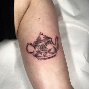 Elegantly designed tattoo by Cristina featuring a beautiful flower, pot, and tea motif. Perfect for those who appreciate nature and relaxation.