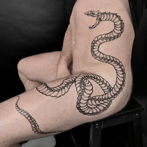 Experience the unique blend of snake and skeleton motifs in this stunning illustrative tattoo by the talented artist Jenny Dubet.