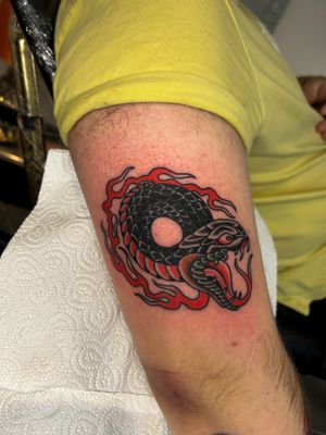 Get a classic traditional snake tattoo by renowned artist Barney Coles, expert in bold and vibrant designs.