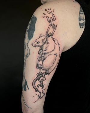 Get inked with a unique illustrative design featuring chains and a rat, expertly crafted by tattoo artist Kat Jennings.