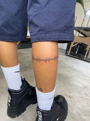 Get a minimalist and detailed barbed wire tattoo by talented artist Charlie Macarthur. Perfect for those looking for a subtle yet edgy design.