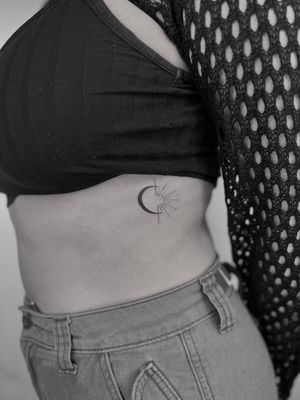 Embrace the delicate balance of sun and moon with this stunning blackwork tattoo by the talented artist Ruth Hall.