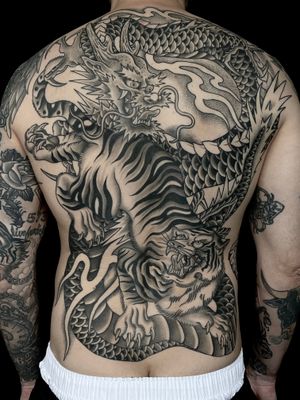 Black and Grey Tiger Vs. Dragon full back piece by Nate Fierro @natefierro #japanese #traditional #traditionaltattoo #dragontattoo #tigertattoo #backtattoo #blackandgrey #blackandgreytattoo #japanesetattoo