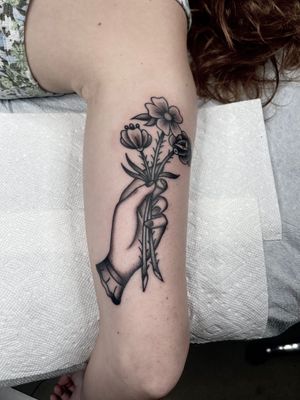Traditional Hand holding flowers tattoo by Nate Fierro @natefierro #traditional #traditionaltattoo #floraltattoo #armtattoo #blackandgrey #blackandgreytattoo