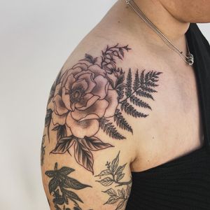 Get a stunning illustrative tattoo of a flower and fern, expertly done by the talented artist Paula. Transform your body into a work of art!