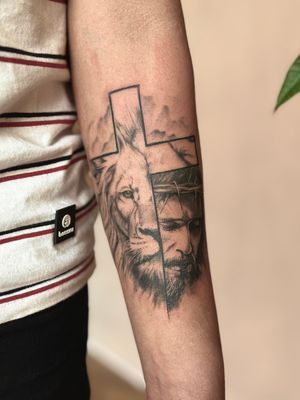 Get an awe-inspiring black and gray tattoo of a lion with a religious twist by Saka Tattoo.