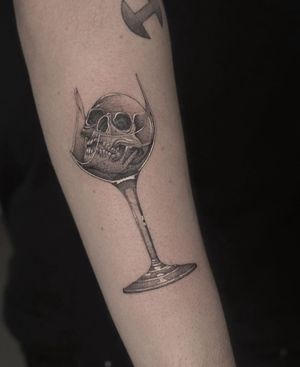 Get a stunning black and gray tattoo of a skull encased in glass by HellHabits. Perfect for lovers of realism tattoos.