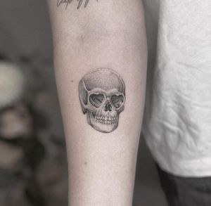 Express your love with this haunting black and gray illustrative tattoo featuring a heart and skull motif by HellHabits.