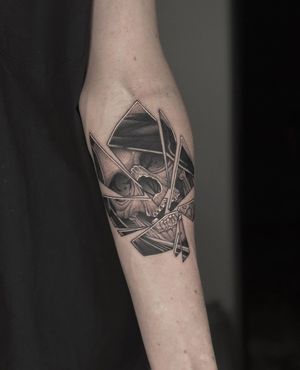 An illustrative tattoo featuring a skull, grim reaper, shards of glass, and a reflective mirror by HellHabits.