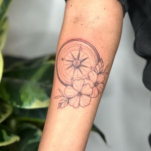 Explore new directions with this delicate fine line floral tattoo by jadeshaw_tattoos. A beautiful fusion of nature and navigation.