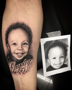 Capture the innocence and beauty of childhood with a stunning black and gray baby portrait tattoo by the talented artist at Simon Says Ink.