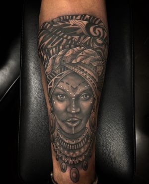 Capture the beauty and strength of an African woman with this stunning black and gray illustrative tattoo by Simon Says Ink.