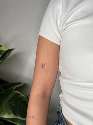 Get inked with a delicate clover tattoo by Emma InkBaby for a stylish symbol of luck. Perfect for minimalistic tattoo lovers.