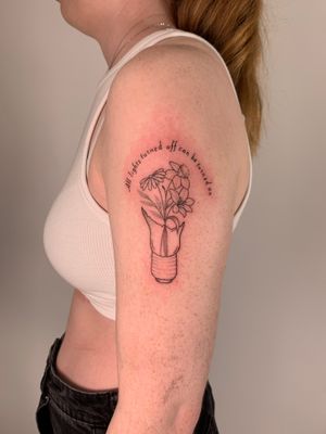 Beautiful fine line tattoo combining a delicate flower and a glowing light bulb in illustrative style by Chloe Hartland.