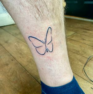 Beautiful hand-poked butterfly tattoo by Charlotte Pokes, with a unique illustrative style.