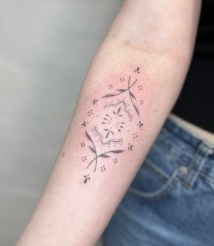 Elegantly crafted by Marketa.handpoke, this dainty tattoo features intricate dotwork in an ornamental design.