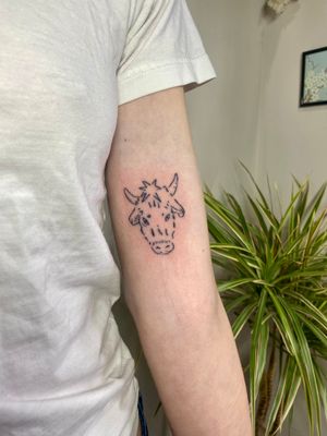 Get a unique hand-poked cow tattoo in illustrative style by talented artist Charlotte Pokes.