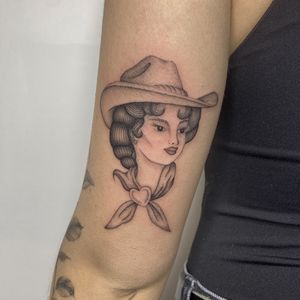 A stunning black and gray illustrative tattoo of a traditional cowgirl lady, expertly crafted by artist Charlie Macarthur.